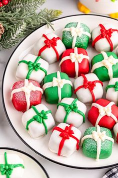 a white plate topped with lots of different types of candies next to christmas decorations