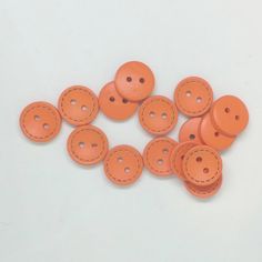 orange leather buttons with stitching on white background