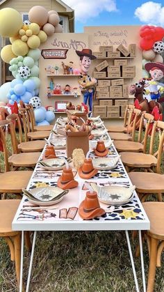 a table set up for a birthday party with balloons and decorations