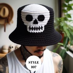 a man wearing a black and white crocheted hat with a skull on it