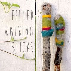 an old pair of walking sticks sitting on the side of a white wall next to a sign that says felted walking sticks