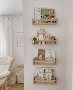 three wooden shelves with books and stuffed animals on them in the corner of a room