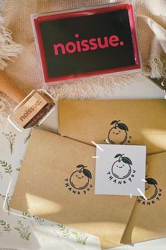 two brown envelopes with the words noisie on them and a rubber stamp