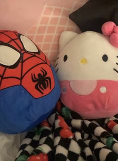 hello kitty and spiderman stuffed animals are laying next to each other