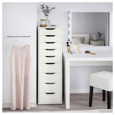 a white dresser sitting next to a dressing table