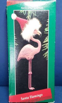 a pink flamingo christmas ornament with a santa hat