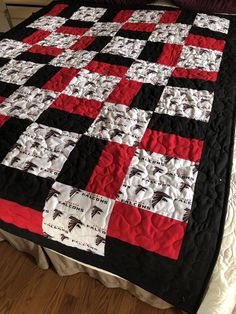 a black and red quilt on top of a bed