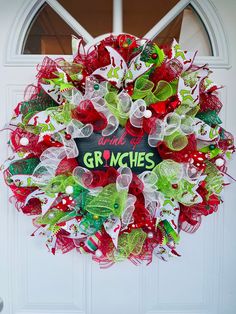 a wreath that says welcome to the grinches with green, red and white decorations