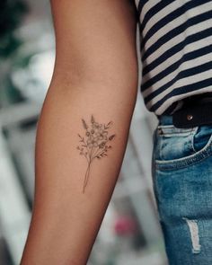 a woman's arm with a flower tattoo on the left side of her arm