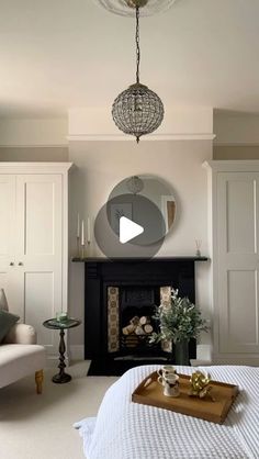 a living room with a fireplace, mirror and table in the middle of the room