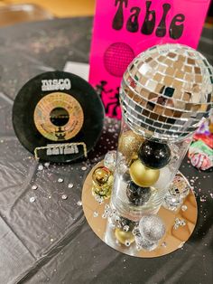 a disco ball is sitting on top of a small table with other items around it