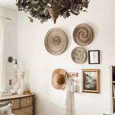 three baskets hanging on the wall above a bed