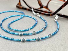 Dainty and bohemian eyeglass necklace chain in blue/Turquoise tones, made with Preciosa Czech crystal seed beads tiny silver plated crystal seed beads and delicate light blue cubic zirconia crystal beads. Paired with grey blue cubic zirconia crystal beads, this handmade eyeglass chain will definitely create a unique look.  The eyeglass lanyard is made on strong quality beading wire with silver plated wire guardians that protect the quality eyeglass holder grips. The necklace is ended with spring Beaded Eyeglass Chain, Glasses Cord, Sunglasses Necklace, Crystal Sunglasses, Eyeglass Necklace, Blue Sunglasses, Eyeglass Chain, Eyeglass Holder, Grandma Gift