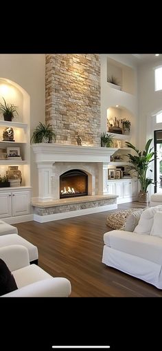 a living room with white furniture and a fireplace