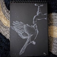 a notebook with a drawing of a bird drinking from a faucet on it