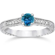 an engagement ring with blue topazte and diamonds on the sides, set in 18k white gold