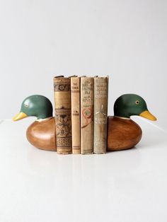 three books are stacked on top of each other in the shape of a duck