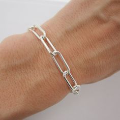 "SOLID 925 STERLING SILVER This unique bracelet is hand-crafted out of solid sterling silver and features a thick and chunky \"paperclip\" style chain. The rectangle links measure approximately 15mm long and 6mm wide. Bracelet is available in your choice of length and closes with an easy-to-use lobster claw clasp. Comes in a gift box. More paperclip bracelets available here: www.etsy.com/shop/TheVioletGoat?ref=seller-platform-mcnav&search_query=paperclip+bracelet SIZING - IMPORTANT: To determine bracelet size, measure snugly around the wrist and add 1 inch. Because this chain has large links, it can be clipped anywhere for an adjustable fit. If you're unsure of size, I recommend sizing up. RETURNS/EXCHANGES: Due to the high cost of materials for this bracelet, I'm unable to accept returns Luxury Rectangular Sterling Silver Chain Bracelet, Classic Sterling Silver Bracelet With Paperclip Chain, Everyday Sterling Silver Bracelet With Chunky Chain, Everyday Sterling Silver Chunky Chain Bracelet, Classic Silver Link Paperclip Bracelet, Sterling Silver Link Bracelets With Paperclip Chain, Sterling Silver Bracelets With Paperclip Chain, Silver Chain Bracelet With Paperclip Link, Sterling Silver Everyday Bracelet With Chunky Link Chain