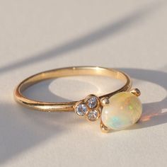 Opal Engagement Ring 14K Gold, Solid Yellow Gold (your choice - White or Rose Gold) Natural Opal 6x8 mm 3 (1,25 mm) Diamonds (conflict free), round cut, color/clarity - F/VS1 Band thickness: 2 mm Go Custom Ask for customization of this ring or make a completely new one: one2threejewelry.com/pages/custom-rings. Feel free to contact: contact@one2threejewelry.com Classic Cluster Birthstone Ring, Classic Round Cut Opal Birthstone Ring, Dainty Cluster Ring With Gemstone, Classic Opal Ring With Round Cut, Classic Opal Round Rings, Dainty 14k Gold Round Opal Ring, 14k Gold Oval Opal Promise Ring, Dainty 14k Gold Opal Ring, Oval Opal Ring With Prong Setting In 14k Gold