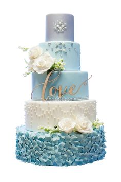 a three tiered cake with white flowers on top and blue frosting in the middle