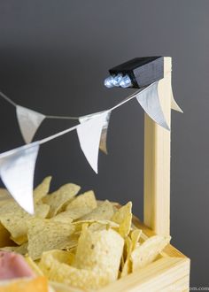 a box filled with chips next to a light on top of a wooden pole and bunting