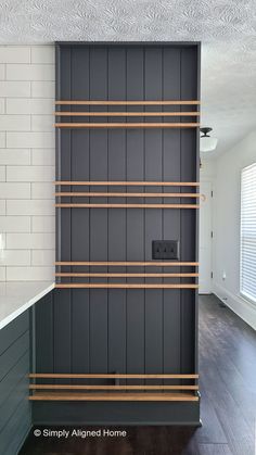 a kitchen with black cabinets and wooden shelves