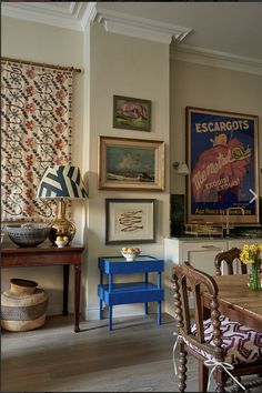 a dining room filled with furniture and pictures on the wall