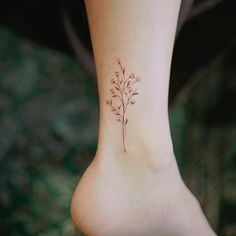 a small flower tattoo on the side of a woman's foot is shown in this image