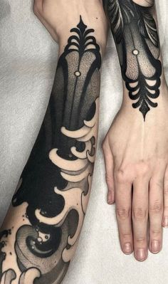 two hands with black and white tattoos on them