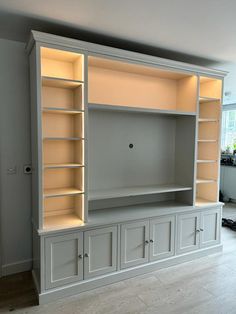 a white entertainment center with built - in shelving unit and lights on the shelves