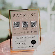 a business card sitting on top of a wooden table next to a white fluffy ball