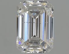 an emerald cut diamond on a white background with the center stone in between two smaller diamonds