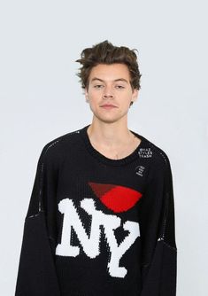 a young man wearing a black sweater with the word ny on it and red lips