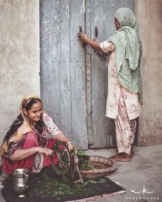 two women sitting on the ground near a door