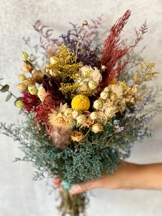 a person holding a bunch of flowers in their hand