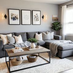 a living room with gray couches and pictures on the wall above them, along with a coffee table