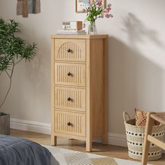 a bedroom with a bed, chair and wooden dresser in it's corner next to a potted plant