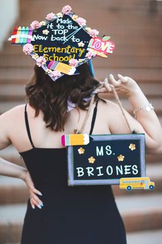 a woman wearing a graduation cap and holding a sign