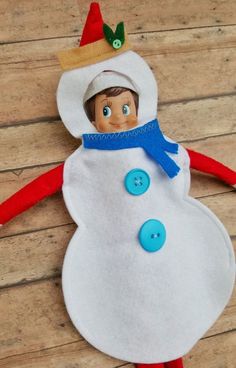 an elf is making a snowman made out of felt with buttons on his head