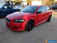 a red car parked in a parking lot next to other cars