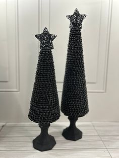 pair of black beaded christmas trees on pedestals