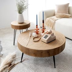 a living room with two tables and a phone on the coffee table in front of it