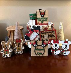 mickey mouse christmas decorations are displayed on a table in front of a tree and other items