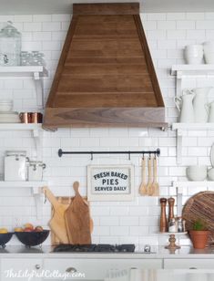 a stove top oven sitting inside of a kitchen next to white cabinets and counter tops