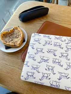 a table topped with a cookie next to a cup of coffee and an ipad case