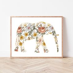 an elephant with flowers on it's back is standing in front of a white wall