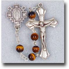 Adorned with brown and gold semi precious stones, the 6 mm Genuine Gem Stone Tiger Eye Rosary makes a fierce statement in religious accessories. Matching silver tone accents bring out the various hues of each bead, creating a lovely article of the faith to be placed in an equally dainty giftbox. Spiritual Nickel-free Brown Jewelry, Brown Crucifix Jewelry Gift, Brown Crucifix Jewelry For Gifts, Brown Crucifix Spiritual Jewelry, Brown Spiritual Crucifix Jewelry, Spiritual Brown Crucifix Jewelry, Spiritual Brown Jewelry With Polished Beads, Spiritual Brown Polished Bead Jewelry, Brown Beaded Rosary With Cross Shape