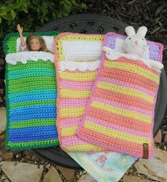 two crocheted baby blankets, one with a doll and the other in it