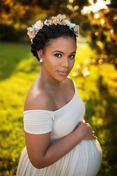 a pregnant woman wearing a flower crown in the grass