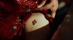 a close up of a person wearing a red dress and holding something in their hand